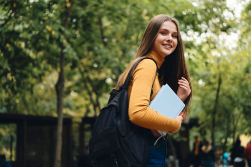 girl carrying books and a backpack